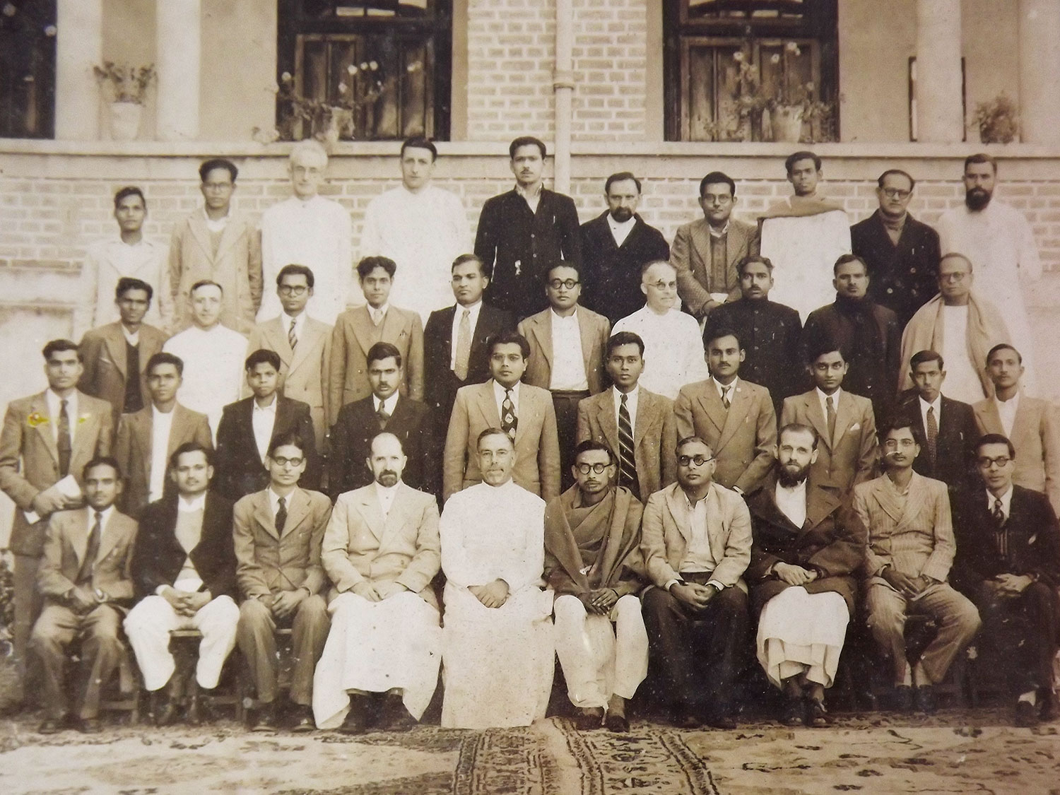 Vintage photo showing a group of Belgian and India college professors posing for an annual photo shoot in 1953