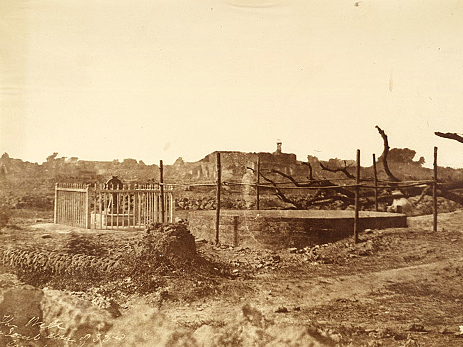 Image is a vintage photo of the well of Bibighar in Cawnpore, India. The photo was captured by Doctor John Murray in 1858.