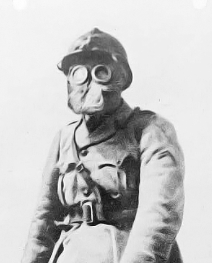 Image is a cropped section of a vintage photo showing a French Sergeant wearing a M2 Gas Mask, 1916.
